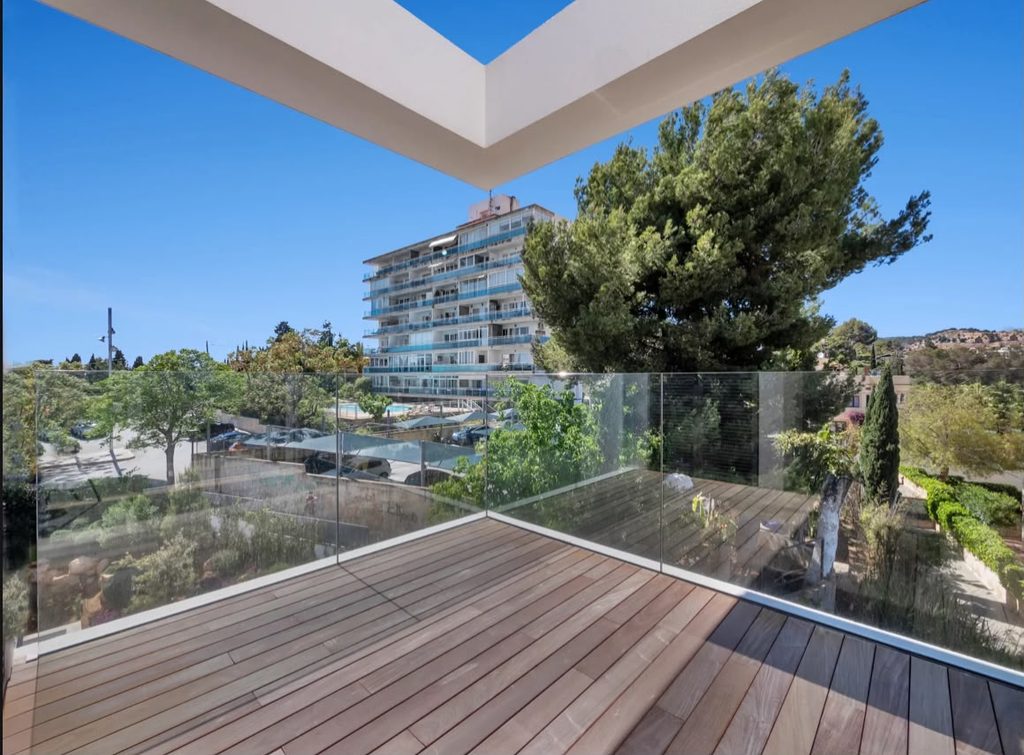 Terraza con suelo de madera y barandilla de vidrio