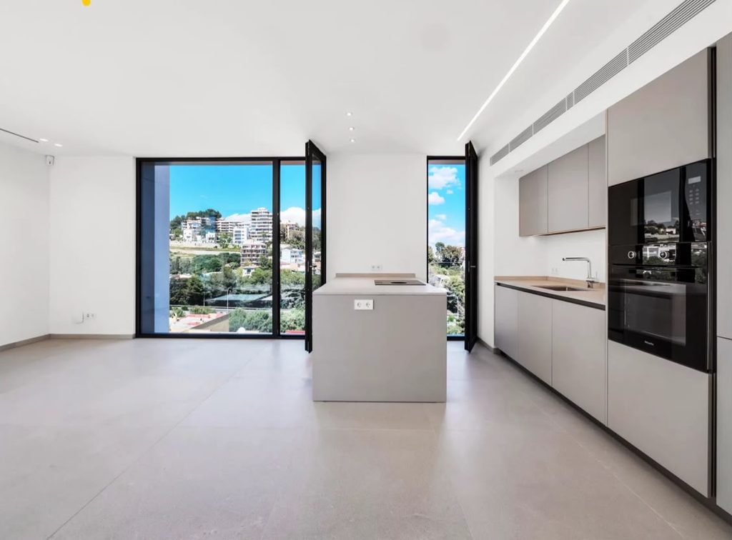 Cocina abierta con isla y salón de la vivienda en MarAdalt