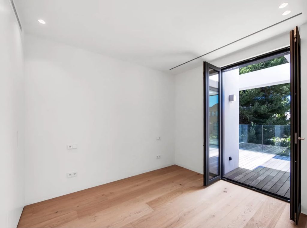 Dormitorio con suelo de madera y salida al exterior