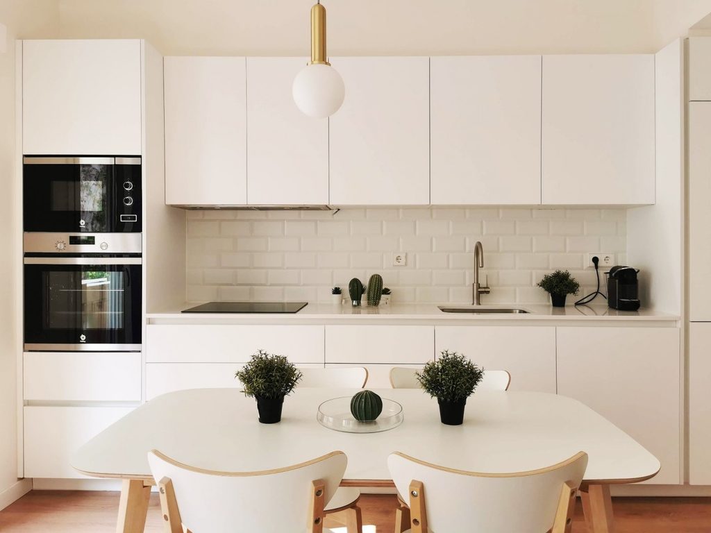 Cocina con armarios blancos y electrodomésticos integrados
