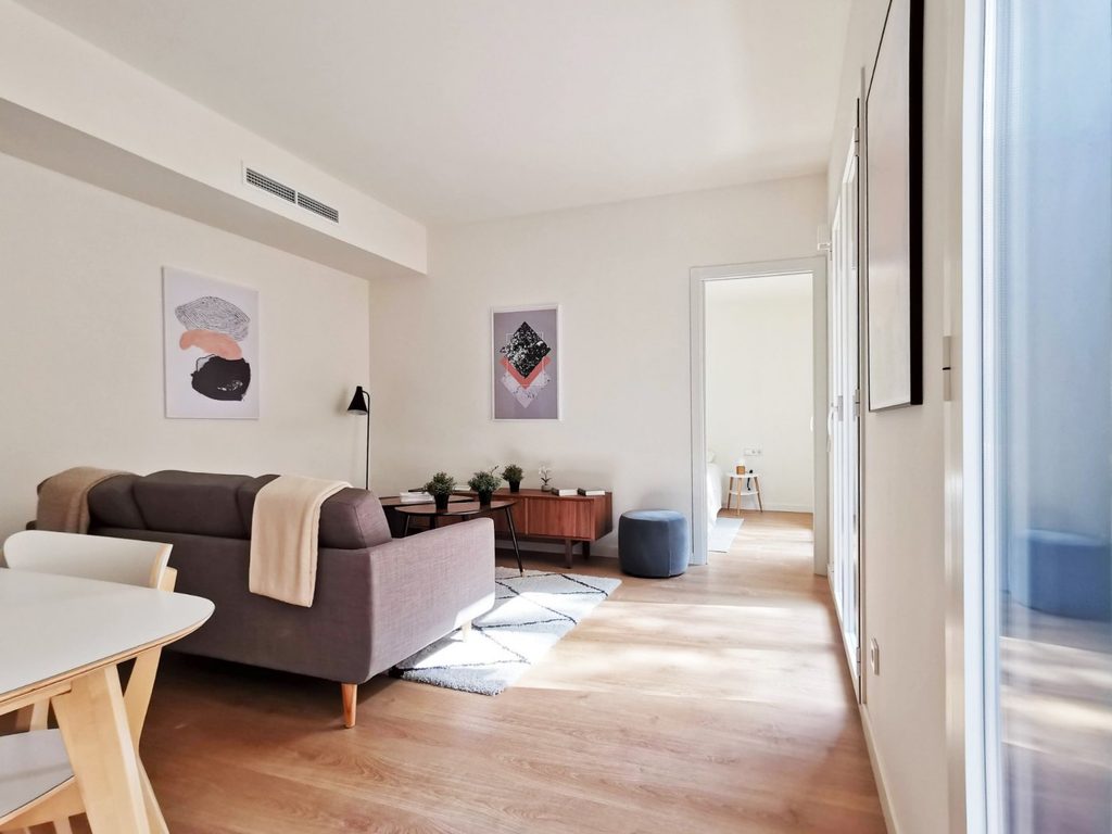Zona de estar con sofá y suelo de madera